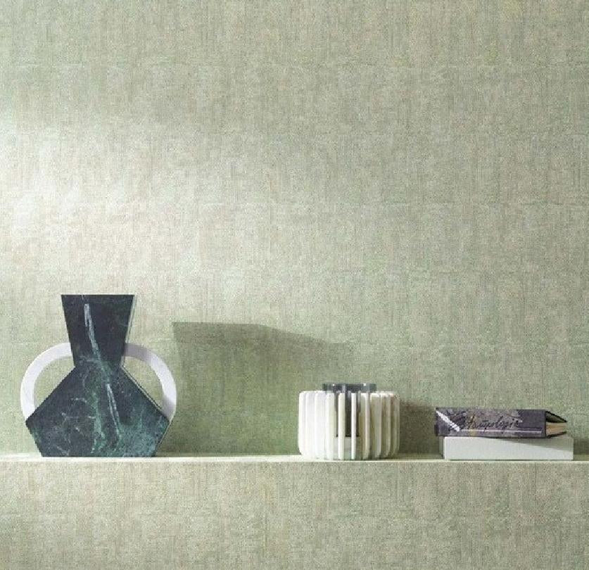 A wallpaper sample display for Artisan Decor, featuring a textured sage green wallpaper on a wall with decorative objects on a shelf, alongside a vertical color swatch panel labeled 'Biscan' showing the product code ACPT3NCC and dimensions.