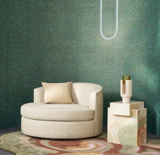 A wallpaper sample presentation for Artisan Home Decor, featuring the 'Faenza' pattern in a styled living room mockup with a cream curved armchair and a marble side table against a textured teal-green wall. The right side of the image contains a dark panel with color swatches, product details, and the Artisan Home Decor logo.