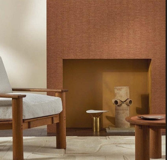 A styled interior scene showing a textured terracotta-brown Nerikomi wallpaper installed on a fireplace wall, alongside a vertical product information panel with color swatches and product details.