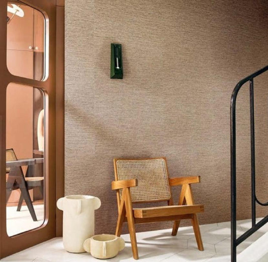 A wallpaper sample presentation showing the 'Occitan Plains' pattern by Artisan Room. The left side displays the wallpaper in a styled room setting with a wooden chair, a black metal railing, and a warm terracotta door.