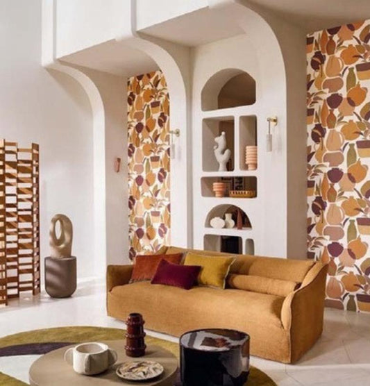 A promotional interior design graphic showing a living room with patterned wallpaper in warm earthy tones, alongside product swatches and text for 'Vallauris' wallpaper by Artisan Room. The right side includes product details: ACPTA44NGC, dimensions 70cm x 10.
